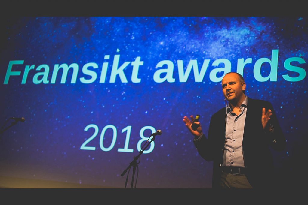 Bilde av mann som står foran en stor skjerm